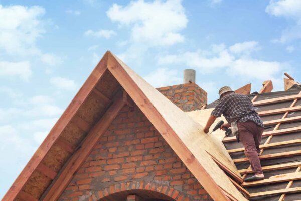 Ouvrier construisant le toit en briques d'une maison.