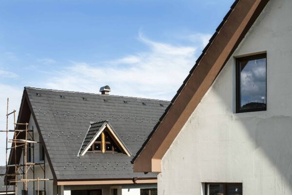 Toit moderne avec fenêtre et ciel bleu.
